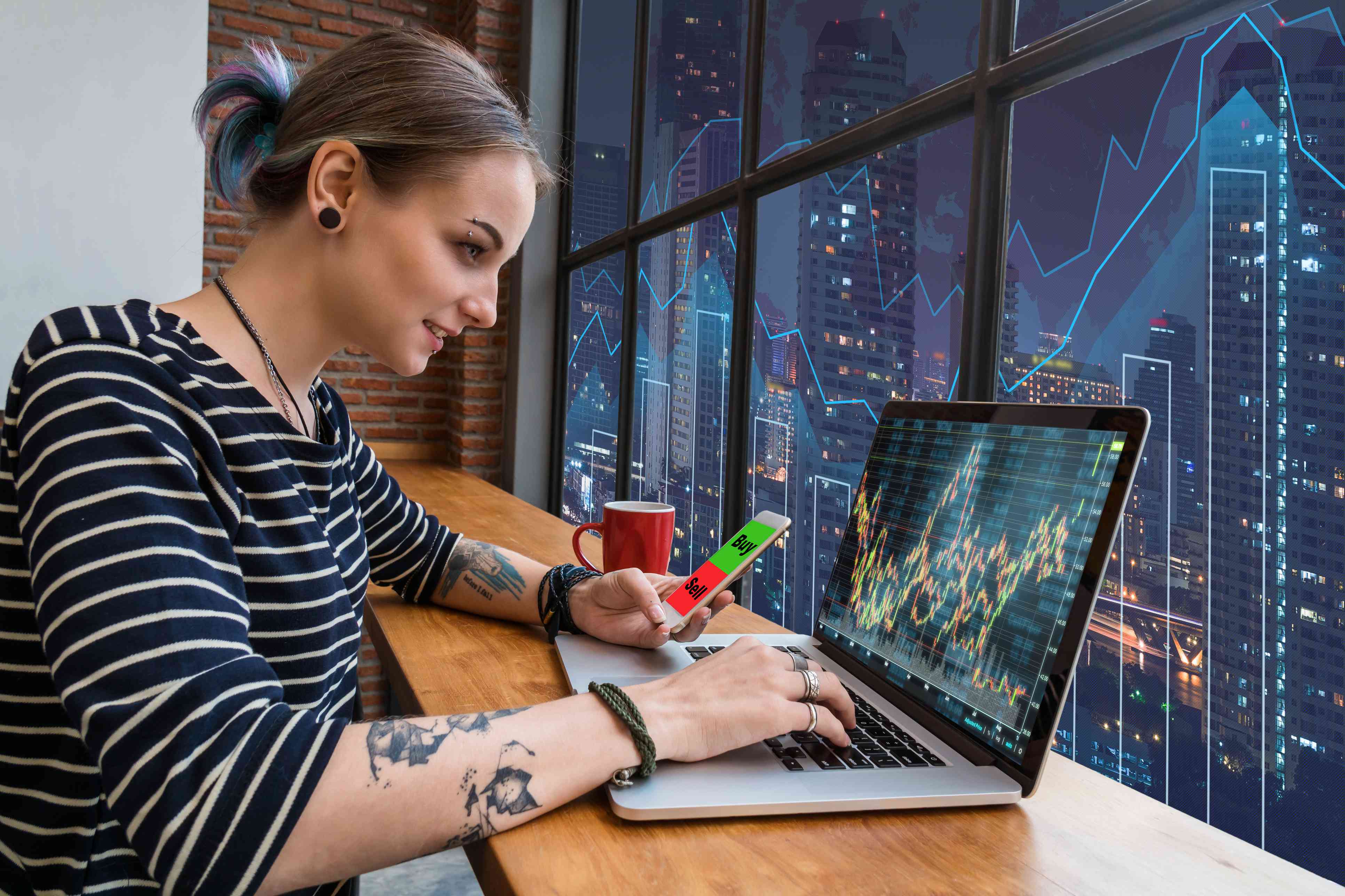 Business financial and forex concept, Hipster young Woman freelancer using the technology laptop and smart phone mobile showing trading graph with the stock exchange trading graph screen background