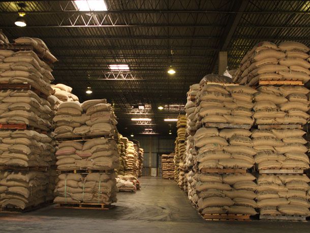 Interior of a warehouse filled with pallets holding sacks of coffee beans.