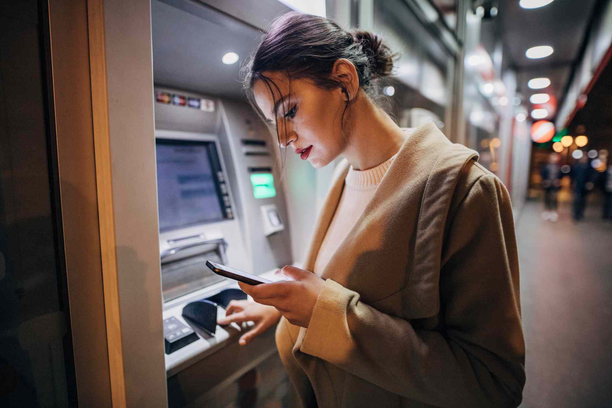 A person makes a transaction at an ATM.