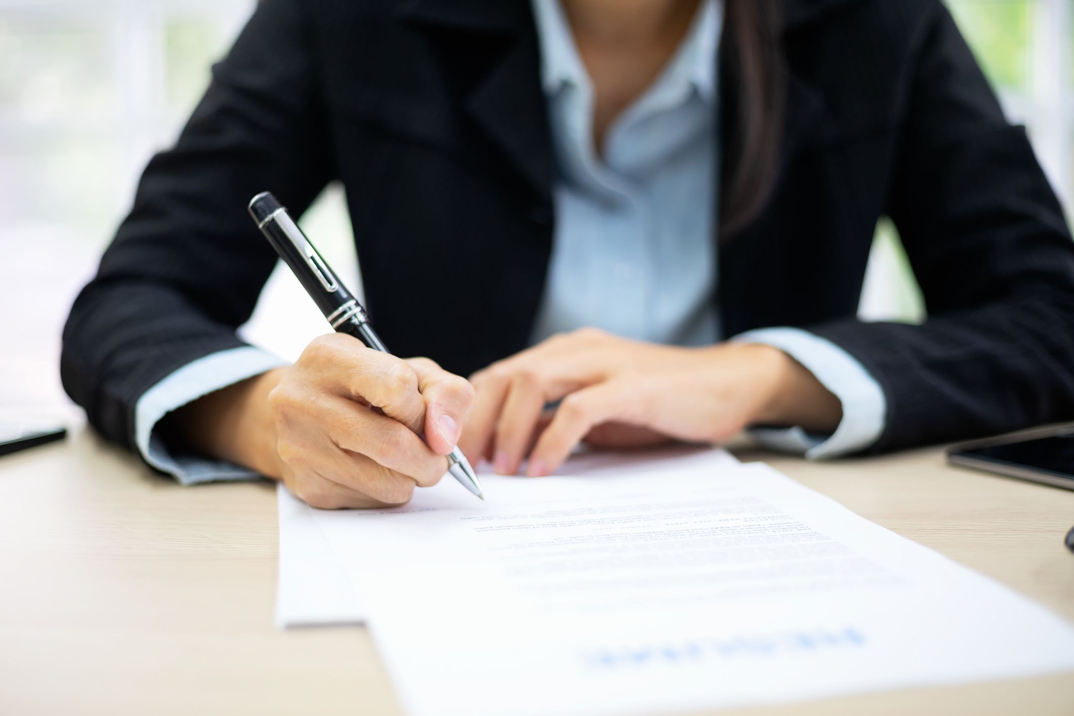 A business woman signing documents.