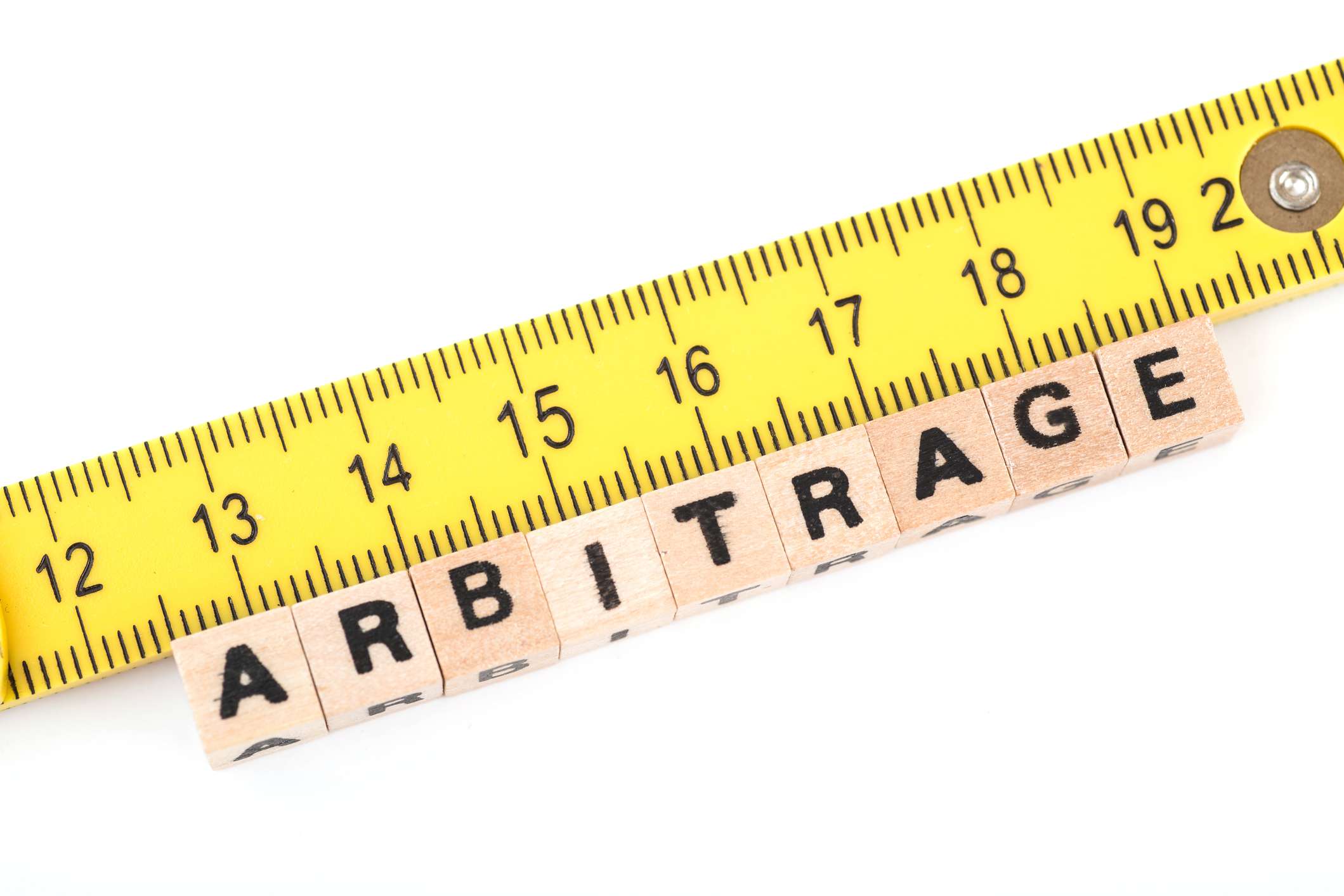 A ruler measuring wood blocks that read arbitrage