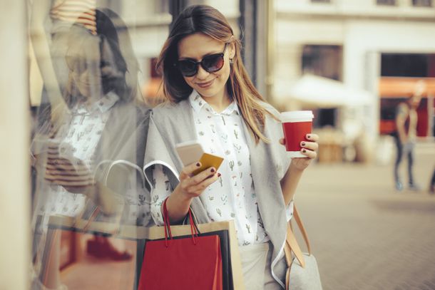 Woman holding a cup of coffee and shopping bags