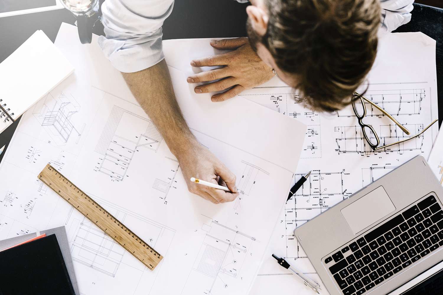 Man Working on Construction Plan at Desk