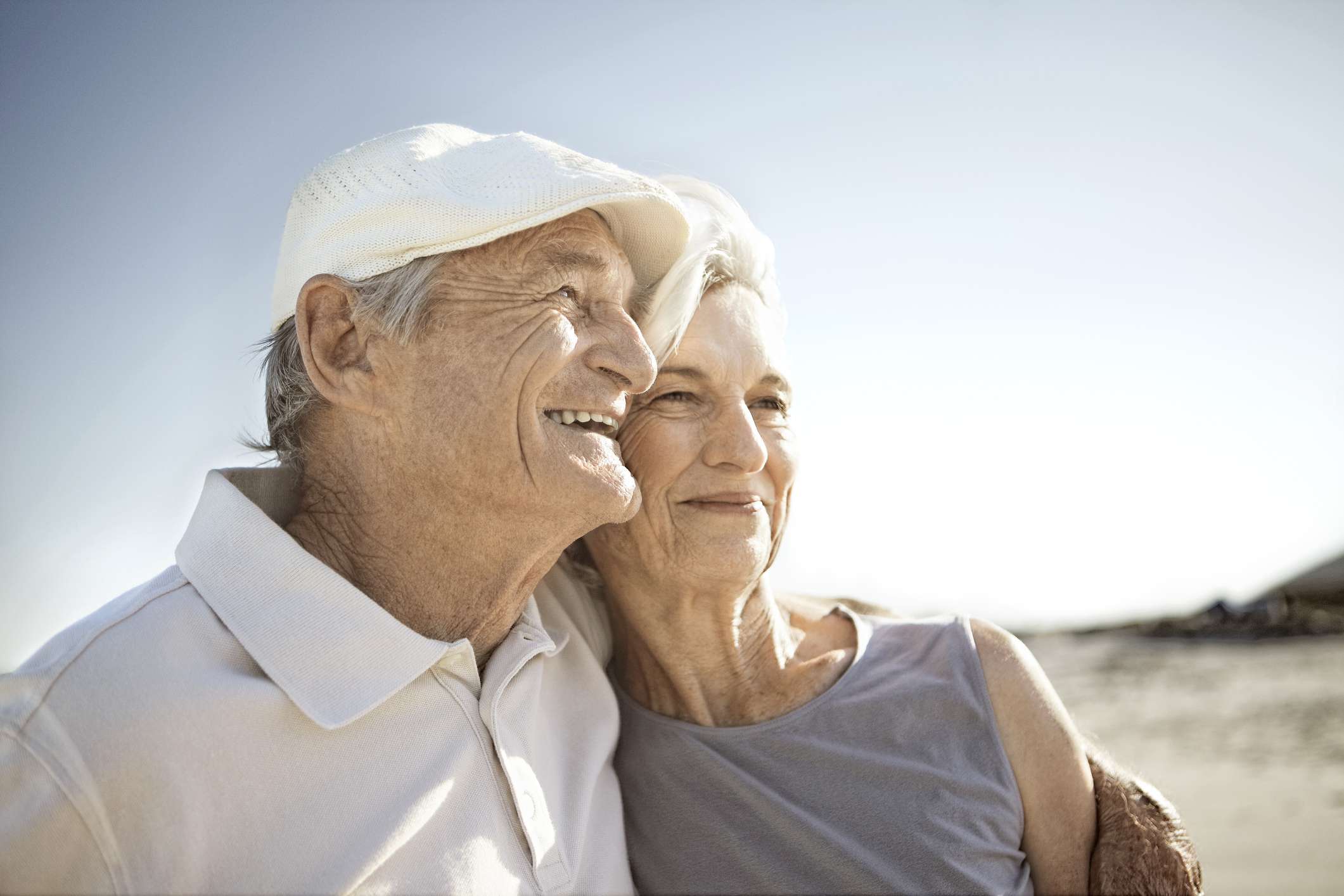 Senior couple together on the beach holding one another