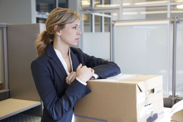Woman staring with arms on a packing box in an office