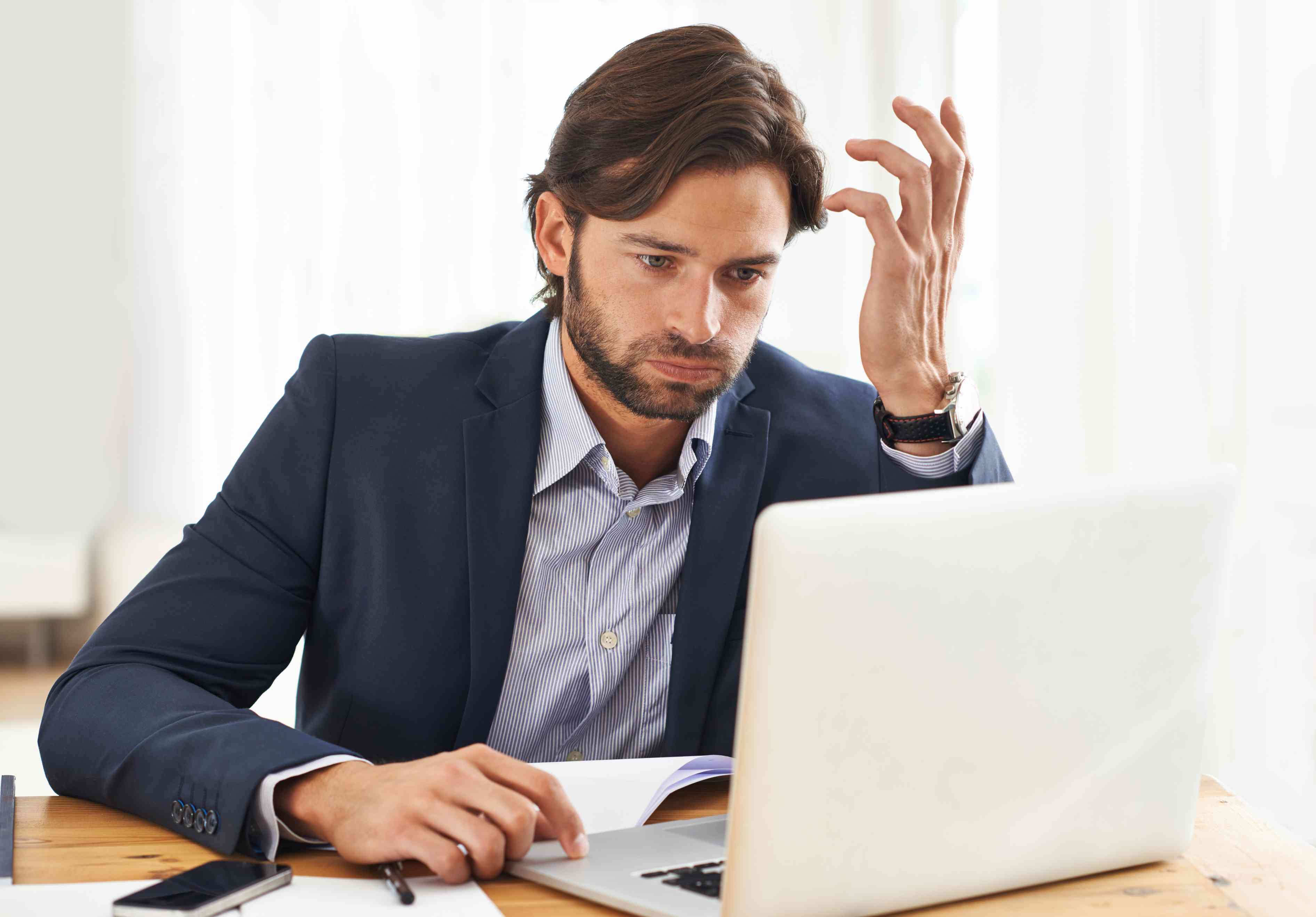Frustrated Man Looks at Laptop Screen 