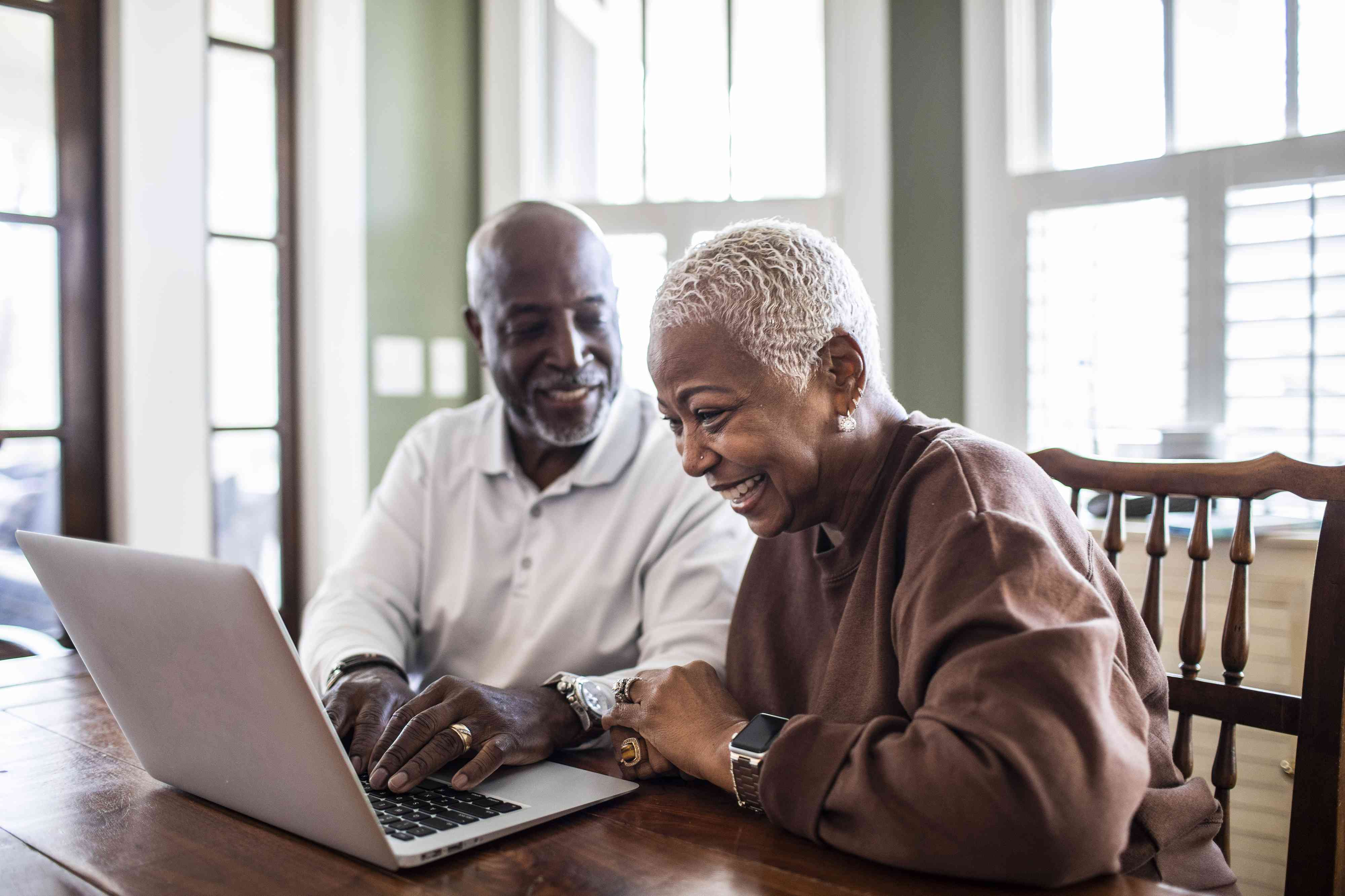 Senior couple using laptop at home to open up an IRA 