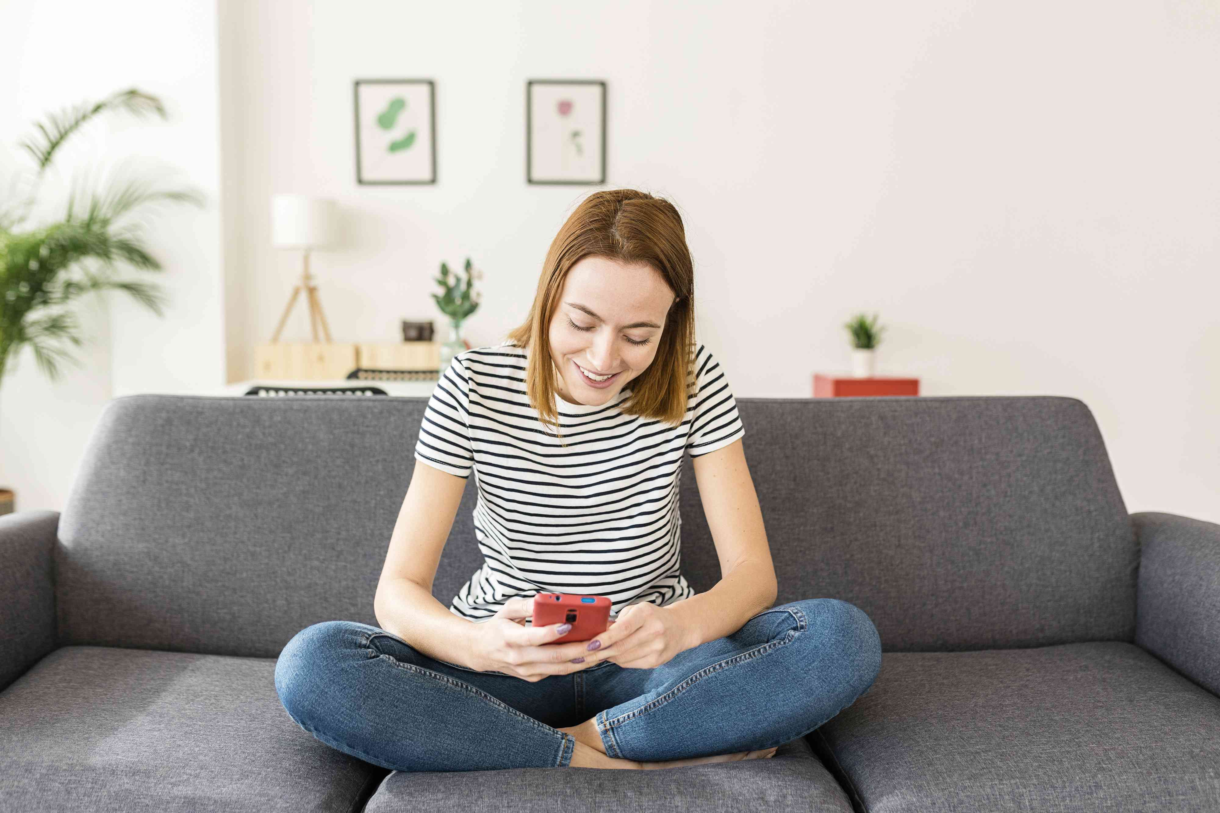 Relaxed young adult woman with cell phone to check savings account