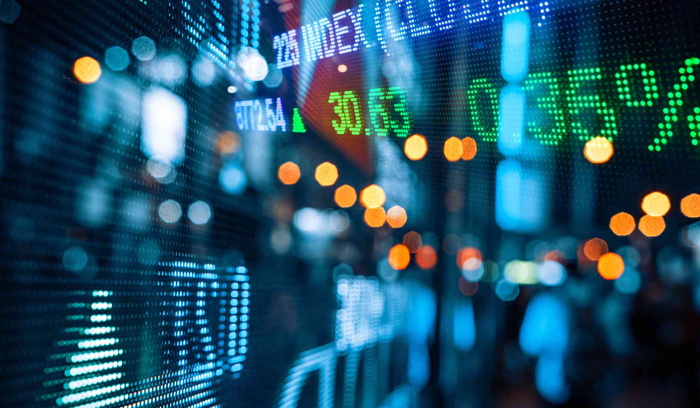 Colorful stock market quotes display reflected on glass